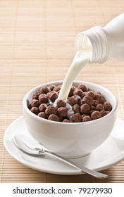 Milk Pouring On Chocolate Cereal Balls Close Up