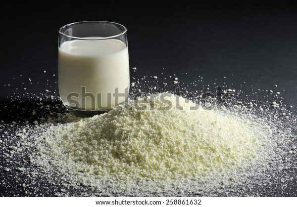 milk powder
with glass of milk on black
background