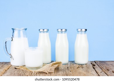 Milk products, Close up of bottle of milk and glass of milk on a old wooden table in vintage pastel color tone on blue background with copy space for text. The Tasty healthy dairy products on a table.