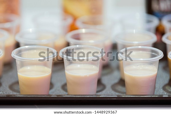 Milk sample in clear plastic container to\
the test on  black tray. Marketing promotion for new launched\
flavor of healthy product. Selective\
Focus