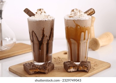 Milk shake blended with ice served with whip cream and chocolate sticks.
