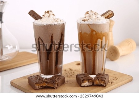 Milk shake blended with ice served with whip cream and chocolate sticks.
