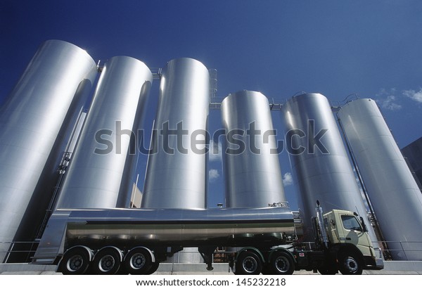 Milk\
transport truck parked alongside storage\
tanks