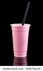 Milkshake in take away cup isolated on black background. reflection on table. Berry, strawberry or other pink color fruit milk cocktail. Mockup or mock up template concept