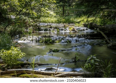 The milky waters of Weaver's Creek flow gently over the rocks in Harrison Park in Owen Sound, Ontario.