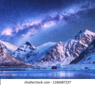 Milky Way above houses and snow covered mountains in winter at night. Starry sky, small village, snowy rocks in Lofoten Islands, Norway. Nordic landscape with milky way, water, ridge, buildings. Space - Powered by Shutterstock