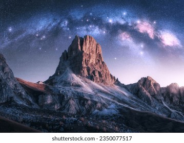 Milky Way acrh over beautifull rocks at starry night in autumn in Dolomites, Italy. Landscape with purple sky with stars and bright arched milky way over high alpine rocky mountains. Space. Nature - Powered by Shutterstock