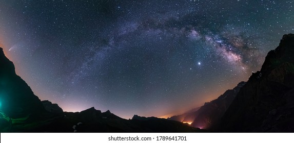 Milky Way arc and stars in night sky over the Alps. Outstanding Comet Neowise glowing at the horizon on the left. Panoramic fish eye view, astro photography, stargazing. - Powered by Shutterstock