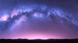 Milky Way Arch. Fantastic Night Landscape With Bright Arched Milky Way, Purple Sky With Stars, Pink Light And Hills. Beautiful Scene With Universe. Space Background With Starry Sky. Galaxy And Nature