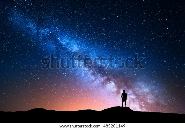 银河系 美丽的夜空与星星和一个独立的人在山上的轮廓 蓝色的银河系和人在山上 背景与银河和一个人的剪影 宇宙库存照片 立即编辑