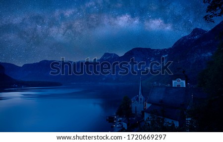 Milky way in the night with famous Hallstatt mountain village with Hallstaetter Lake in the Austrian Alps, region of Salzkammergut, Austria