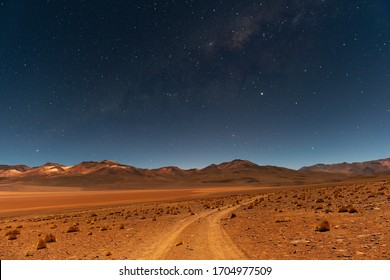 The Milky Way at night on the road in the Siloli Desert with the Andes mountain peaks in the background, Uyuni Salt Flat region, Bolivia.  - Powered by Shutterstock