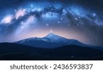 Milky Way over the beautiful Goverla mountain with snow covered peak at night in summer in Ukraine. Colorful landscape with bright starry sky with Milky Way arch, snowy rocks, hills. Space. Nature 