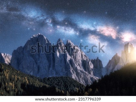 Milky Way over beautifull rocks at starry night in summer in Dolomites, Italy. Landscape with blue sky with stars, bright milky way, moonrise over high alpine rocky mountains, trees. Space. Nature