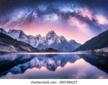 Milky Way over snowy mountains and lake at night. Landscape with snow covered high rocks, purple starry sky, reflection in water in Nepal. Sky with stars. Bright milky way in Himalayas. Space. Nature  - Powered by Shutterstock