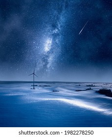 Milky way over wind turbine at night. Alternative energy in winter, Poland. Aerial view of nature in Poland