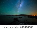 Milky Way Rising Above Lake Tekapo, New Zealand with Aurora Australis Or The Southern Light Lighting Up The Sky . Noise due to high ISO; soft focus / shallow DOF due to wide aperture used.