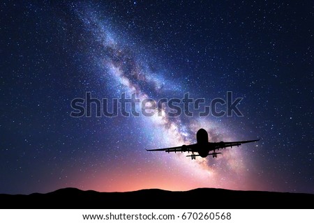 Milky Way and silhouette of a airplane. Landscape with passenger airplane is flying in the starry sky at night. Space background. Landing airliner on the background of colorful Milky Way. Aircraft.
