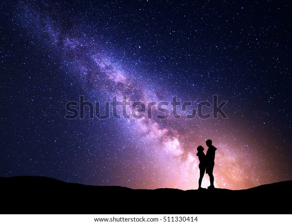天の川と人のシルエット 夜の星空の風景 黄色い光を持つ 山の上に立つ男女 紫の天の川に抱き合う夫婦 美しい銀河 宇宙 の写真素材 今すぐ編集