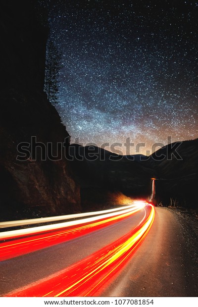 Milky Way Stars and cars lights trails in the\
road. Vertical\
orientation