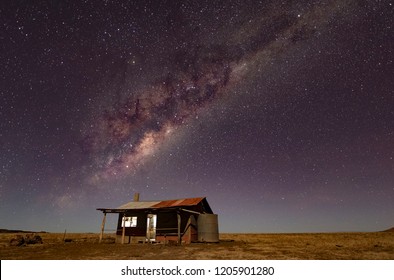 The Milky Way stretches over an abandoned hut in the Australian Outback