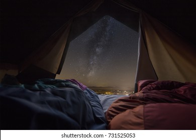 Milky Way View Front Inside A Camping Tent, With A Couple Sleeping Inside