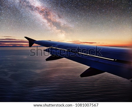 Milky Way with Wing of an airplane. Photo applied to tourism operators. Landscape with passenger airplane is flying in the starry sky at night. Space background. Traveling concept.