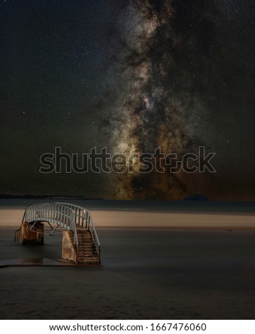 milkyway sky with the public bridge footpath submerged in water, known as the bridge to no where in dunbar, Scotland, uk.