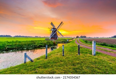Mill by the river at sunset. Windmill farm at sunset. Beautiful sunset on windmill farm. Windmill at sunset landscape