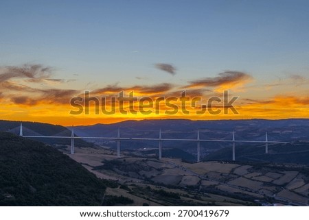 Millau Viaduct cable stayed bridge crossing a valley at vibrant sunset