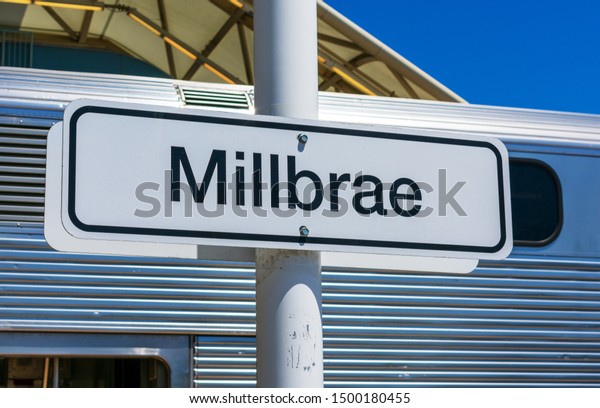 Millbrae Caltrain train station sign, railroad car,\
blue sky. Millbrae station is an intermodal transit station serving\
Bay Area Rapid Transit and Caltrain - Millbrae , California, USA -\
Circa, 2019