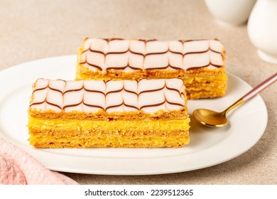 The mille-feuille, or millefeuille, is a piece of French pastry made from three layers of puff pastry and two layers of pastry cream. The top of dessert is iced with icing sugar. - Powered by Shutterstock