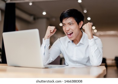 Millenial Asian Business Man In The Office With Laptop Happy With His Victory