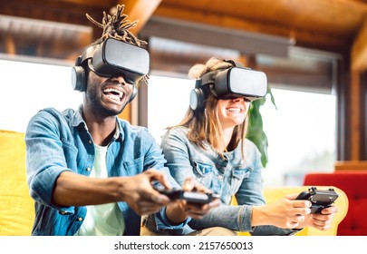 Millenial couple playing with vr glasses at home couch - Virtual reality and tech concept with enthusiastic friends having fun on headset goggles - Generation z digital trends - Bright vivid filter - Powered by Shutterstock