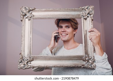 Millenial Young Man Artist With Blonde Hair With Phone On Gilded Picture Frame Portrait.