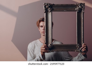 Millenial Young Man Close Face With Gilded Picture Frame Portrait.