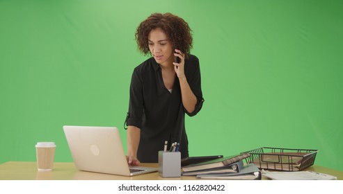 Millennial African American Businesswoman On Phone Using Laptop On Green Screen