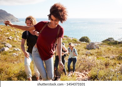 Millennial African American Woman Leading Friends On A Hike Uphill By The Coast, Close Up