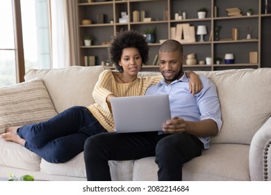 Millennial African married couple paying common bills, insurance, mortgage fees, taxes on internet, making online payments on laptop, using financial banking app on computer at home - Shutterstock ID 2082214684