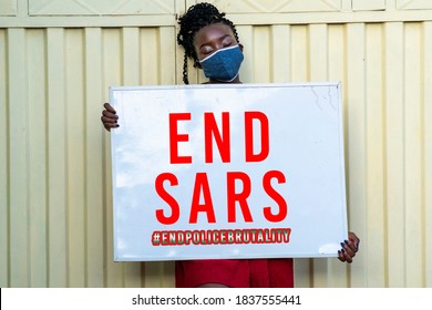 A millennial African woman wearing face mask and holding a sign with end SARS inscription - concept on human rights and police brutality - Powered by Shutterstock