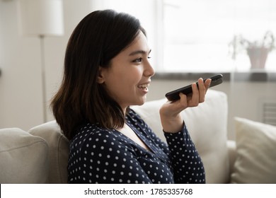 Millennial Asian Female Hold Modern Smartphone Speak Dictate Activate Digital Virtual Voice Assistant On Gadget. Young Vietnamese Woman Talk Record Audio Message, Make Call On Cell.