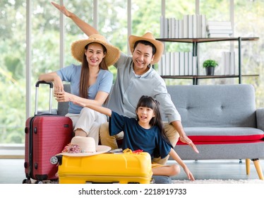 Millennial Asian Happy Family Father Mother And Little Girl Daughter Wearing Casual Summer Travel Outfit Preparing Packing Stuff In Trolley Luggage Ready To Vacation Holiday In Living Room At Home.