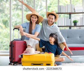Millennial Asian happy family father mother and little girl daughter wearing casual summer travel outfit preparing packing stuff in trolley luggage ready to vacation holiday in living room at home. - Shutterstock ID 2225368573