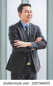 Millennial Asian Happy Successful Professional Male Businessman Entrepreneur In Formal Suit Standing Smiling In Company Office Meeting Room With Big Screen Monitor