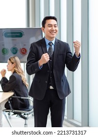 Millennial Asian Happy Successful Professional Male Businessman Entrepreneur In Formal Suit Standing Smiling In Company Office Meeting Room With Big Screen Monitor