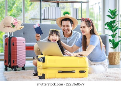 Millennial Asian lovely happy family father mother and young little girl daughter helping packing stuff in trolley luggage preparing to travel on summer vacation reserving hotel and airplane ticket. - Shutterstock ID 2225368579
