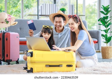 Millennial Asian lovely happy family father mother and young little girl daughter helping packing stuff in trolley luggage preparing to travel on summer vacation reserving hotel and airplane ticket. - Shutterstock ID 2230463539