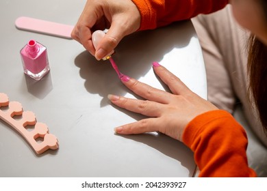 Millennial Asian woman friends sitting on the floor in living room and applying nail polish together. Female friendship enjoy weekend activity lifestyle with beauty treatment and make up at home - Powered by Shutterstock