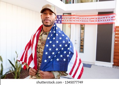 Millennial Black Soldier With US Flag Draped Over His Shoulders, Looking To Camera, Close Up