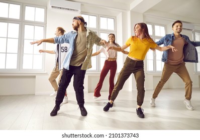 Millennial diverse dancing group or crew training exercising together in studio. Young teen dancers in casual clothes perform prepare for concert. Hobby and entertainment concept. - Powered by Shutterstock